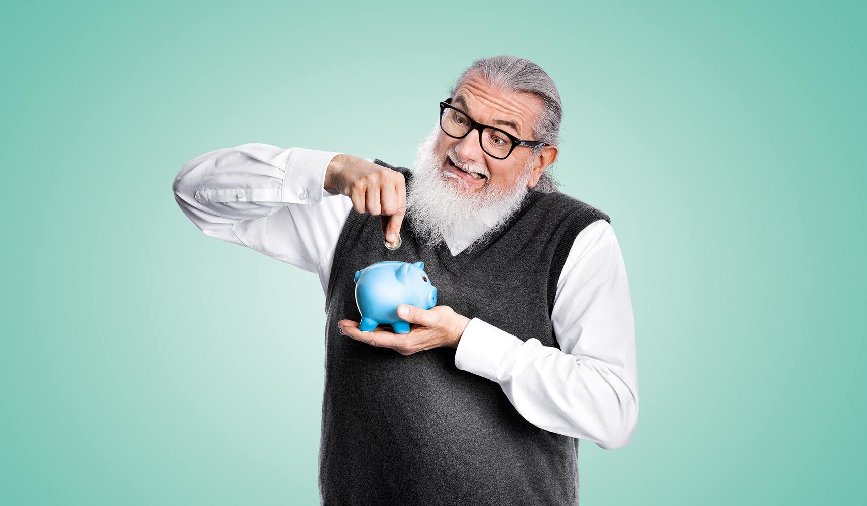 Grimassierender Mann mit Brille füttert Sparschwein mit Münze