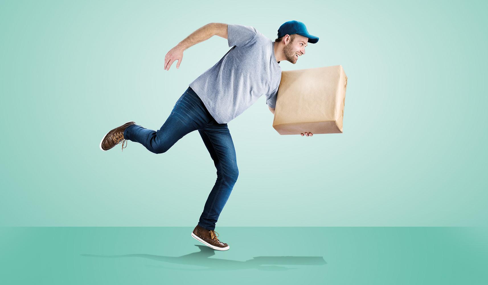 Lieferbote im Laufschritt mit Paket in der Hand