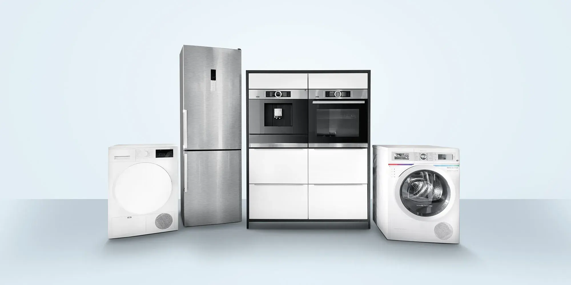 Wäschetrockner, Kühl-Gefrier-Kombigerät, Ausstellungsküchenblock mit Kaffeevollautomat und Backofen und Waschmaschine in leerem, neutralem Raum